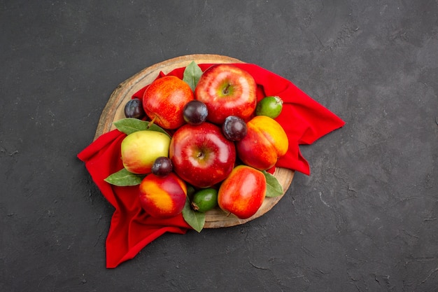 Vista de cima maçãs frescas com pêssegos e ameixas na mesa escura suco suave de árvore de fruta madura