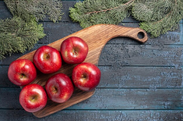 Vista de cima, maçãs vermelhas frescas, frutas maduras e maduras em plantas de mesa azul-escuras, frutas frescas, muitas vitaminas vermelhas