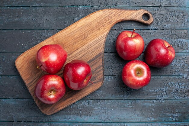 Vista de cima, maçãs vermelhas frescas, frutas maduras e maduras na mesa azul escuro.