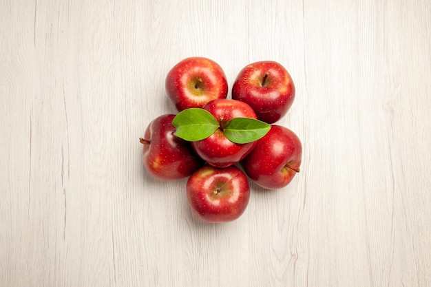 Vista de cima maçãs vermelhas frescas frutas maduras e maduras na mesa branca cor de frutas planta fresca árvore vermelha