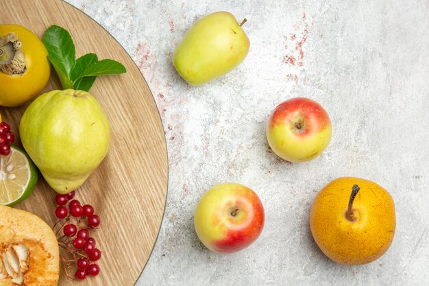 Vista de cima marmelos frescos com outras frutas na mesa branca frutas maduras maduras frescas