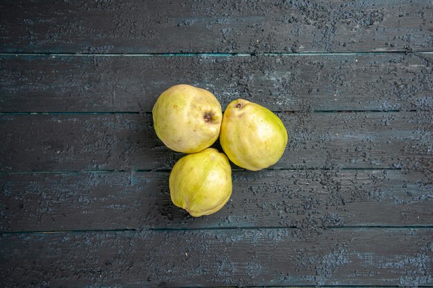 Vista de cima marmelos frescos frutas maduras e ácidas na mesa azul escuro feto maduro árvore fresca planta azeda