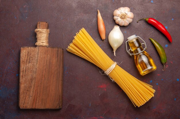 Vista de cima massa italiana crua formada há muito tempo em fundo roxo-escuro refeição massa comida massa vegetal cru