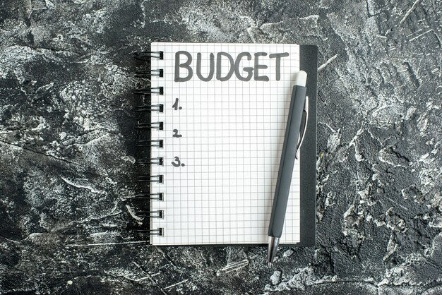 vista de cima orçamento escrito nota no bloco de notas com caneta na cor de fundo cinza caderno escolar estudante universitário lição escura negócios dinheiro