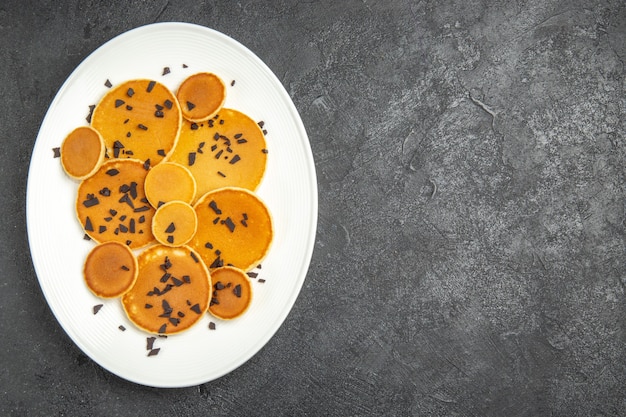 Vista de cima panquecas deliciosas com chips de chocolate no fundo escuro