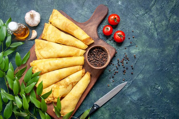 Vista de cima panquecas saborosas enroladas com pimenta em fundo escuro torta de carne pastelaria hotcake bolo doce cor de refeição