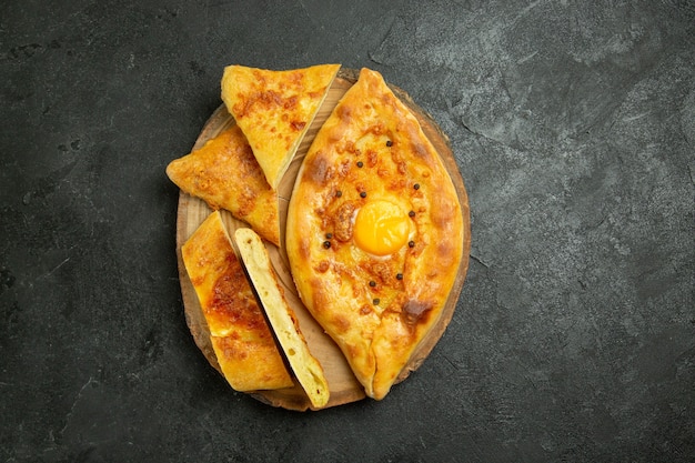 Foto grátis vista de cima, pão com ovo cozido delicioso recém-saído do forno no espaço cinza escuro