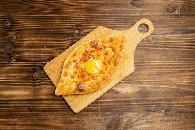Vista de cima pão com ovo delicioso assado na mesa de madeira marrom pão coque ovo
