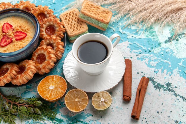 Vista de cima para baixo deliciosos biscoitos de açúcar com waffles xícara de café e sobremesa de morango na superfície azul biscoito biscoito bolo doce cor de sobremesa