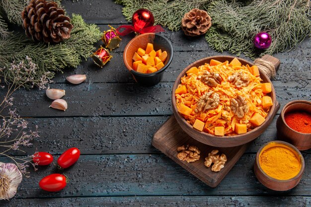 Vista de cima para baixo Salada de cenoura ralada com temperos de nozes na mesa escura salada saudável cor de nozes dieta alimentar