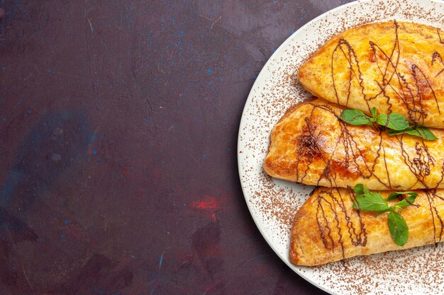 Vista de cima pastéis deliciosos com cobertura dentro do prato no fundo escuro Pastelaria Asse Biscoito Bolo Doce Açúcar