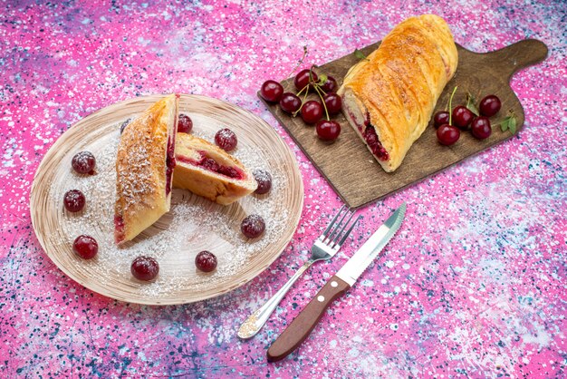 Vista de cima pastelaria de cereja deliciosa e doce fatiada com cerejas frescas dentro do prato no fundo colorido bolo biscoito açúcar doce assar