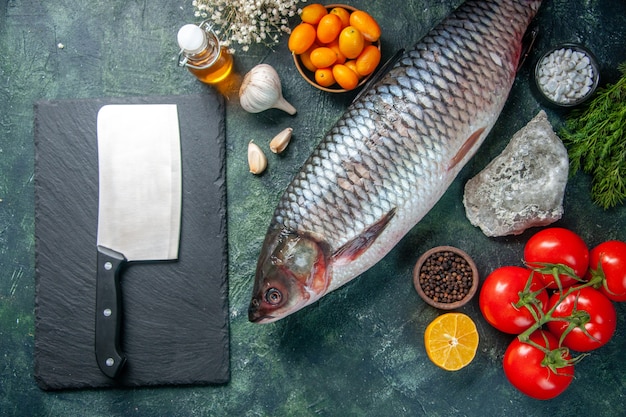 vista de cima peixe cru fresco com tomate vermelho em fundo escuro