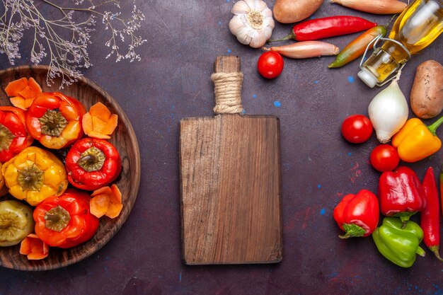 Vista de cima pimentões cozidos com vegetais frescos na mesa escura refeição vegetais carne comida dolma