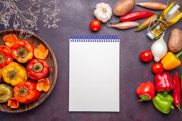 Vista de cima pimentões cozidos com vegetais frescos na superfície escura refeição vegetais carne comida dolma