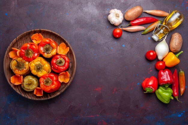 Vista de cima pimentões cozidos com vegetais frescos na superfície escura refeição vegetais carne comida dolma