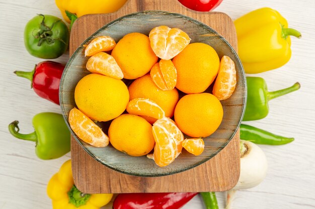 Vista de cima pimentões frescos com tangerinas em um fundo branco salada dieta foto colorida madura vida saudável