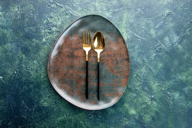 vista de cima prato vazio marrom com colher dourada em fundo escuro restaurante comida cozinha refeição talheres utencil jantar