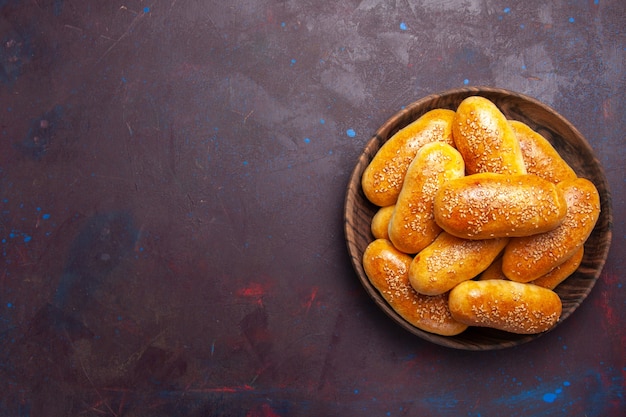 Vista de cima rissóis doces deliciosa massa assada para chá no chão escuro