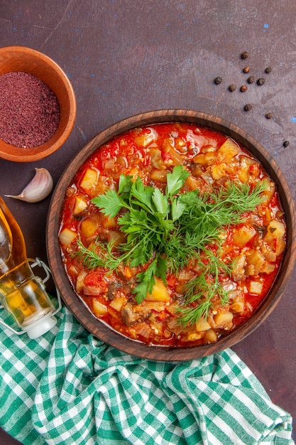 Foto grátis vista de cima saborosa refeição com molho de vegetais cozidos com verduras na superfície roxa escura com molho prato de refeição