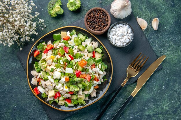 vista de cima saborosa salada de vegetais dentro do prato com talheres em fundo azul escuro cozinha restaurante refeição fresca saúde almoço dieta cor