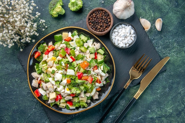 vista de cima saborosa salada de vegetais dentro do prato com talheres em fundo azul escuro cozinha restaurante refeição fresca saúde almoço dieta cor