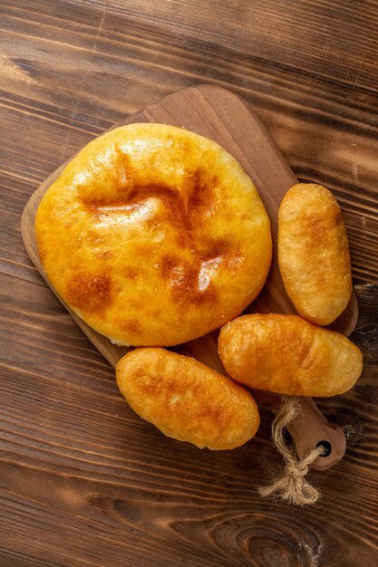 Vista de cima saborosa torta de abóbora com pão quente de batata na mesa de madeira marrom torta bolo quente e forno de cozer