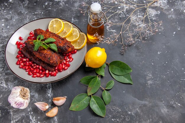 Vista de cima saborosas costeletas de carne com rodelas de limão no fundo cinza prato foto food