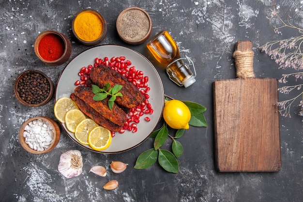 Vista de cima saborosas costeletas de carne com temperos no fundo cinza prato foto comida