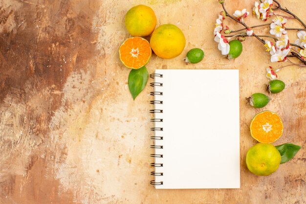 Vista de cima saborosas tangerinas frescas com feijoas e bloco de notas