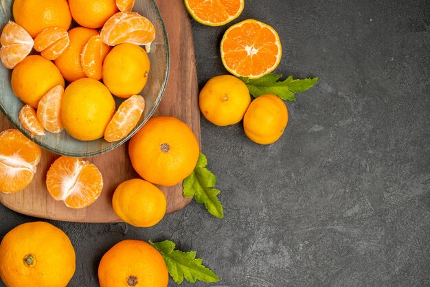 Vista de cima saborosas tangerinas suculentas dentro do prato em fundo cinza