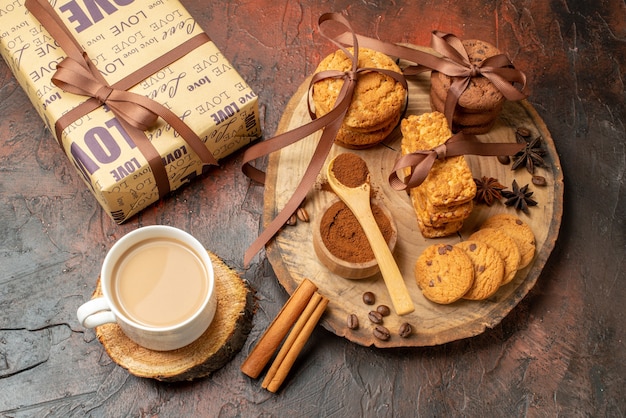 Vista de cima saborosos biscoitos amarrados com anis de biscoitos de corda em uma xícara de café de presente na mesa de madeira