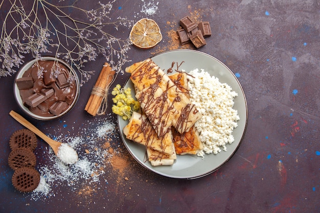 Vista de cima saborosos pastéis doces com chocolate e requeijão em fundo escuro Pastelaria biscoito bolo açúcar doce chá