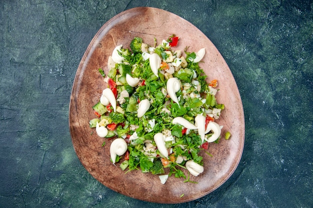 vista de cima salada de verduras vegetais dentro de prato elegante em fundo azul escuro cor dieta refeição cozinha restaurante comida saúde almoço