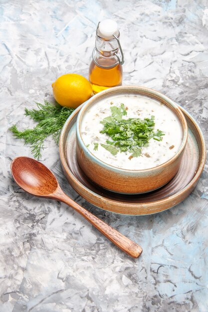 Vista de cima, sopa de iogurte dovga gostosa com verduras em um prato de sopa branco claro