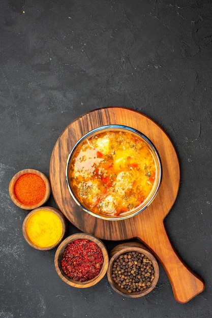 Foto grátis vista de cima sopa saborosa com diferentes temperos no chão cinza refeição comida carne tempero picante