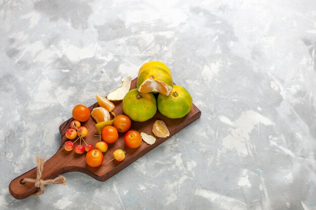 Foto grátis vista de cima tangerinas verdes frescas com cítricos maduros e azedos na mesa branca.