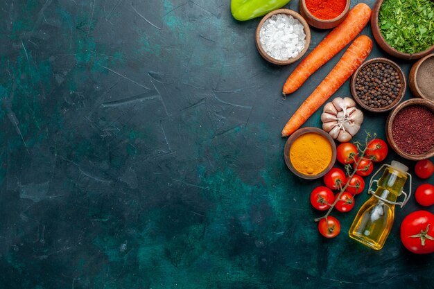 Vista de cima temperos diferentes com tomates frescos em fundo verde escuro ingrediente produto refeição comida vegetal