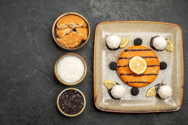 Vista de cima torta saborosa com doces de coco na superfície escura torta sobremesa bolo biscoito chá doce