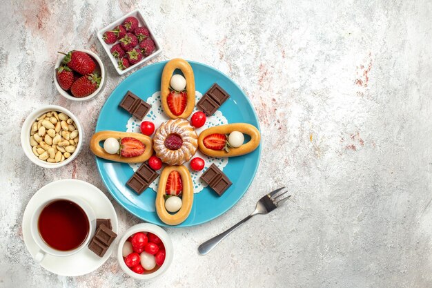 Vista de cima um bolo delicioso com barras de chocolate, chá e biscoitos doces no fundo branco biscoito biscoito doce torta de chocolate