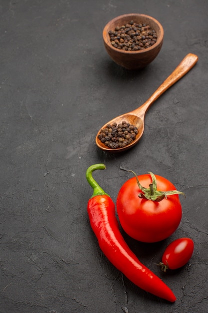 Foto grátis vista de cima uma tigela de pimenta do reino e tomate, pimenta vermelha e tomate cereja no fundo preto