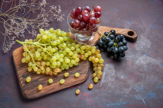 Foto grátis vista de cima uvas frescas maduras na superfície escura vinho uva fresca planta de árvore de fruta madura