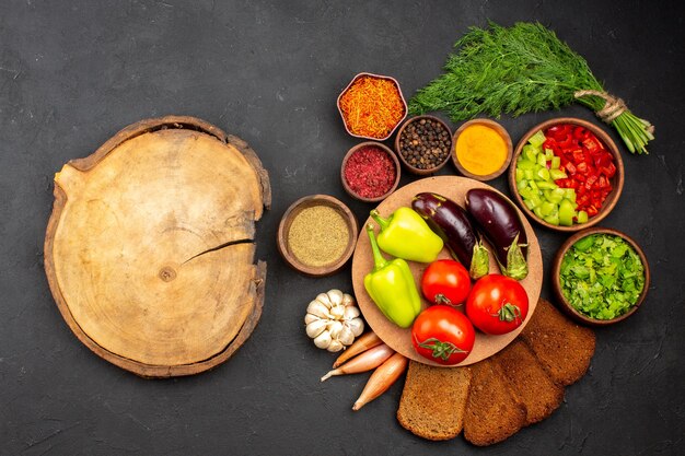 Vista de cima vegetais frescos maduros com verduras e pão preto na superfície escura salada comida refeição vegetais saudáveis