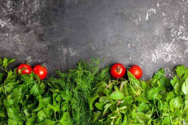 Vista de cima, verdes e tomates em fundo escuro com espaço de cópia