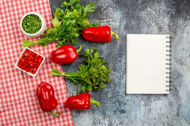 Vista de cima verduras frescas com pimentões vermelhos na mesa cinza claro