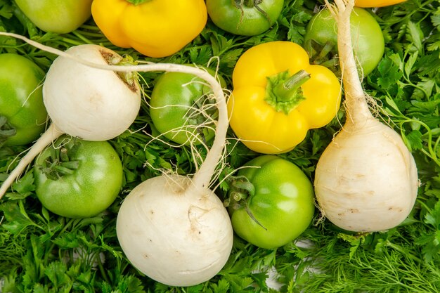 Vista de cima verduras frescas com tomate verde, rabanete e pimentão em fundo branco