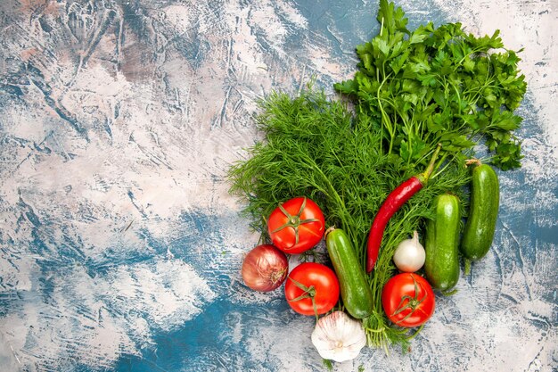 Vista de cima verduras frescas com tomates e pepinos em um fundo claro