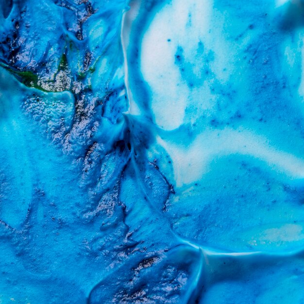 Vista de detalhe de cores azuis e verdes misturadas com espuma branca texturizada