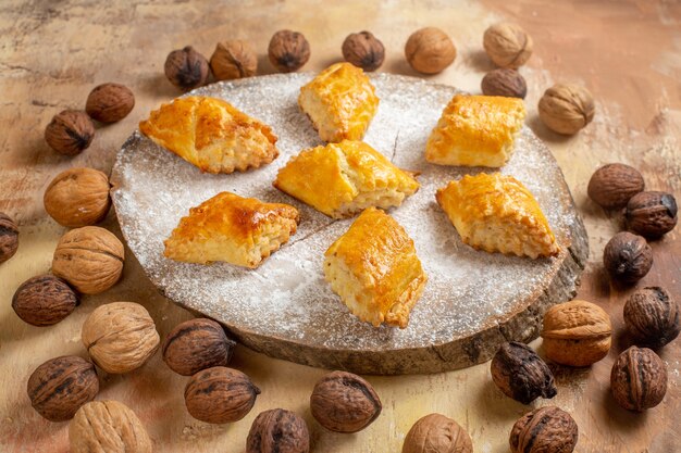 Vista de frente deliciosos pastéis de nozes com nozes em uma mesa leve torta de bolo doce