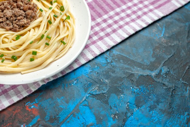 Foto grátis vista de frente saborosa massa italiana com carne moída em prato azul de comida de massa de carne